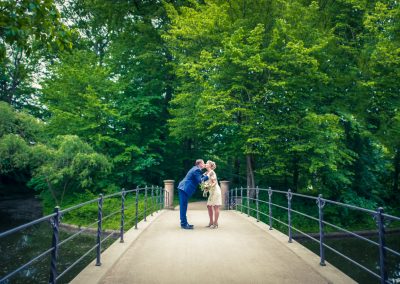 Brudepar kysser på bro i park. København