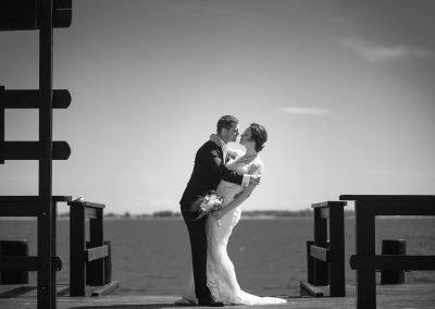 Brudepar kysser på stranden. Bryllupsfoto
